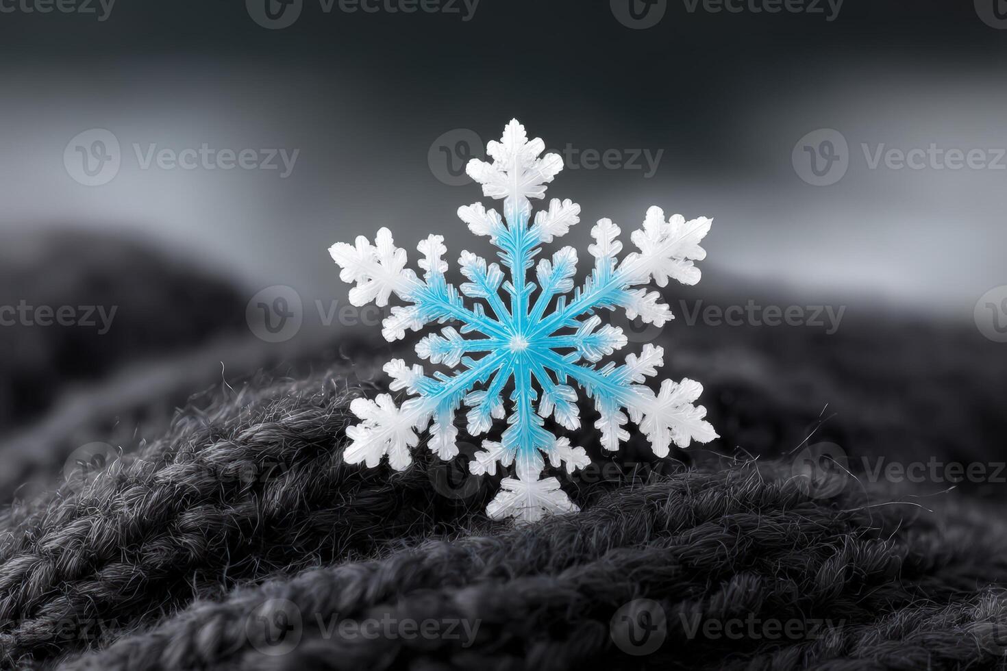 Snowflake with eight arms rests on a cozy black knit fabric photo