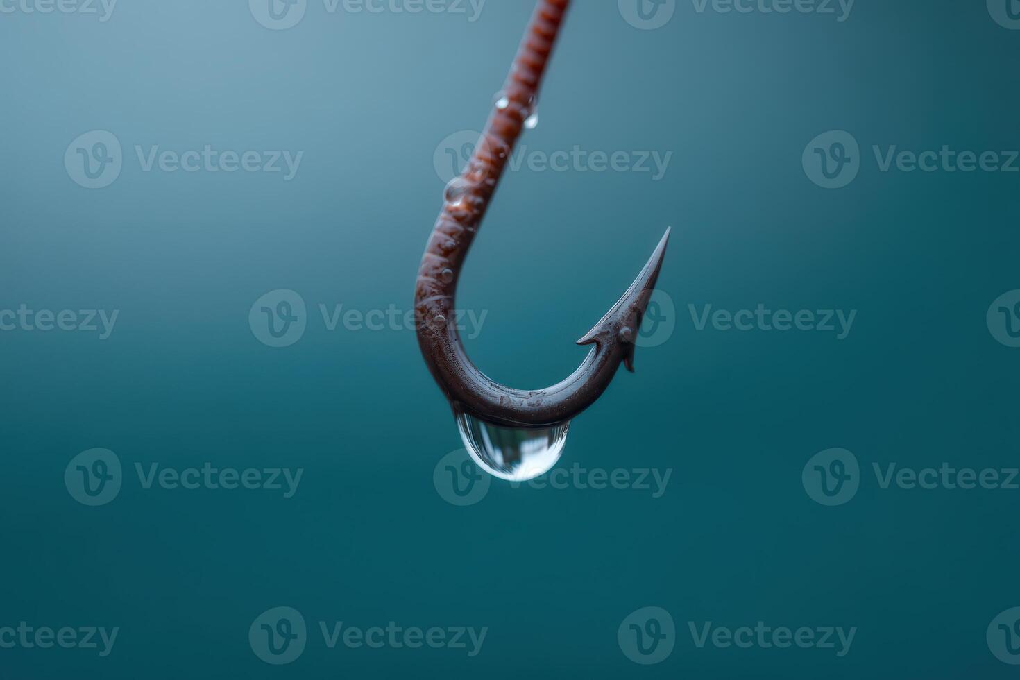 Hook dangling above water surface with a drop of water at the tip photo
