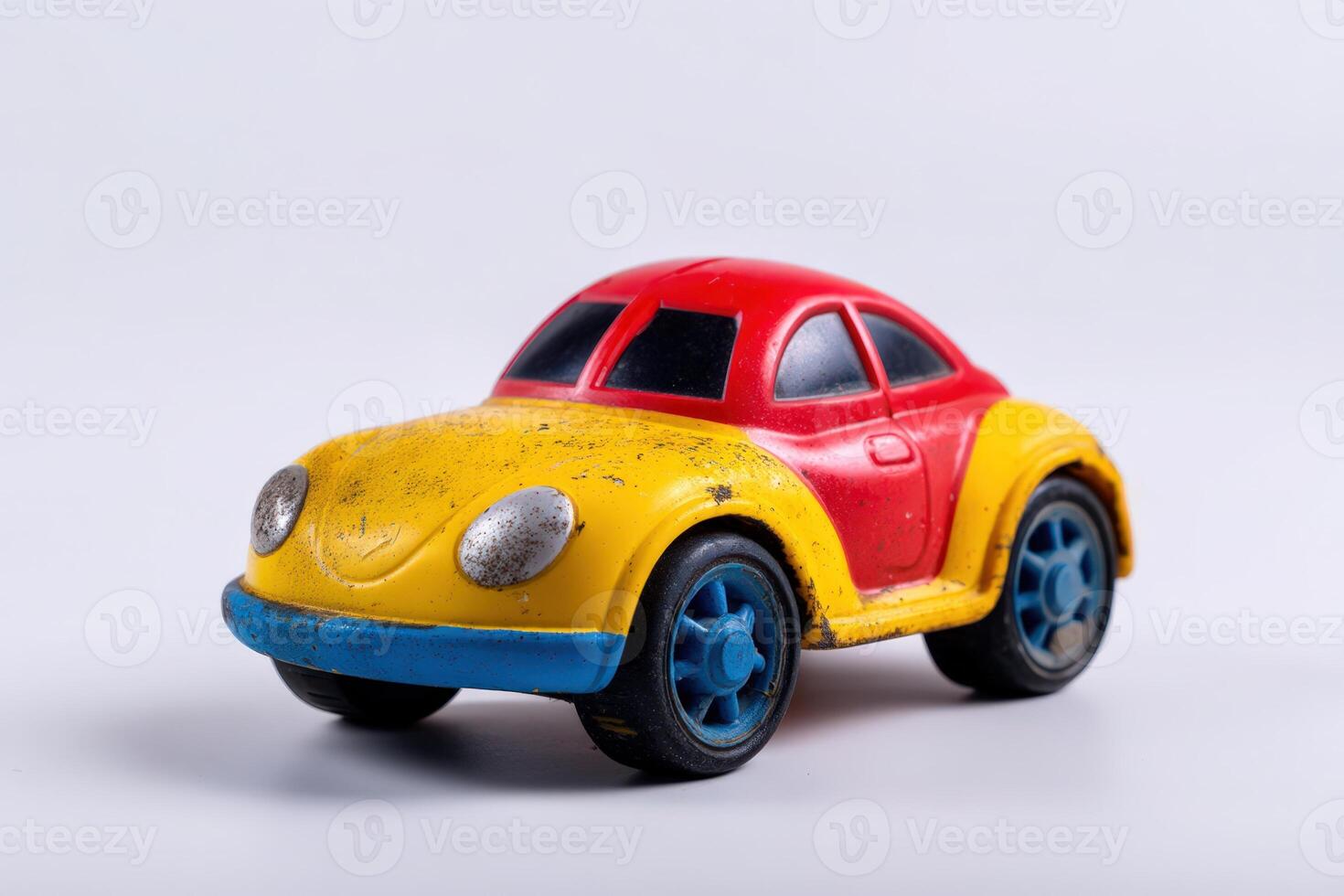 Colorful toy car with scratches on its surface sits against a plain backdrop photo