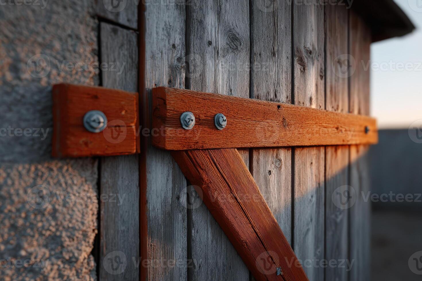 Rustic wooden barn door with sturdy metal hinges in warm evening light photo