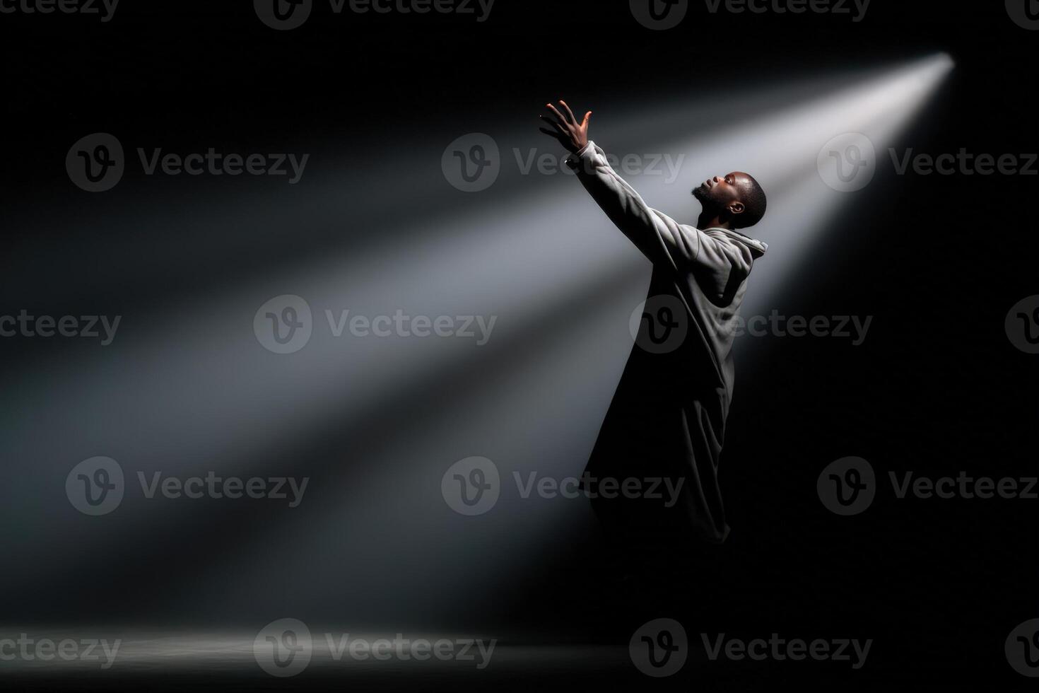 Performer reaches for his shadow under dramatic stage lighting during a captivating moment photo