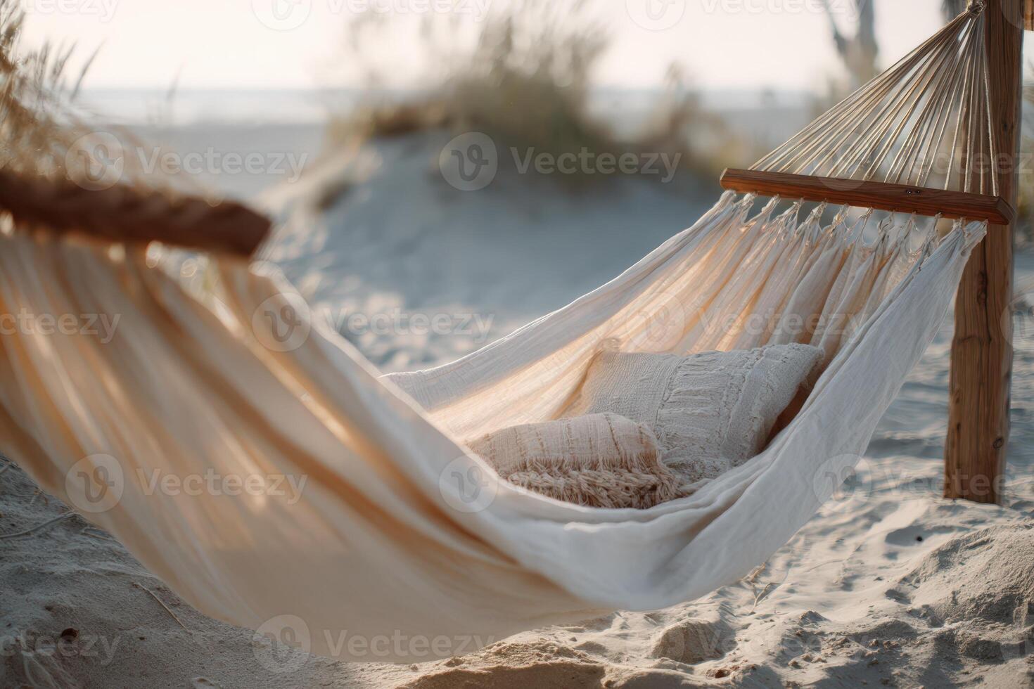 Chic beige hammock swaying gently on sandy beach during sunset photo
