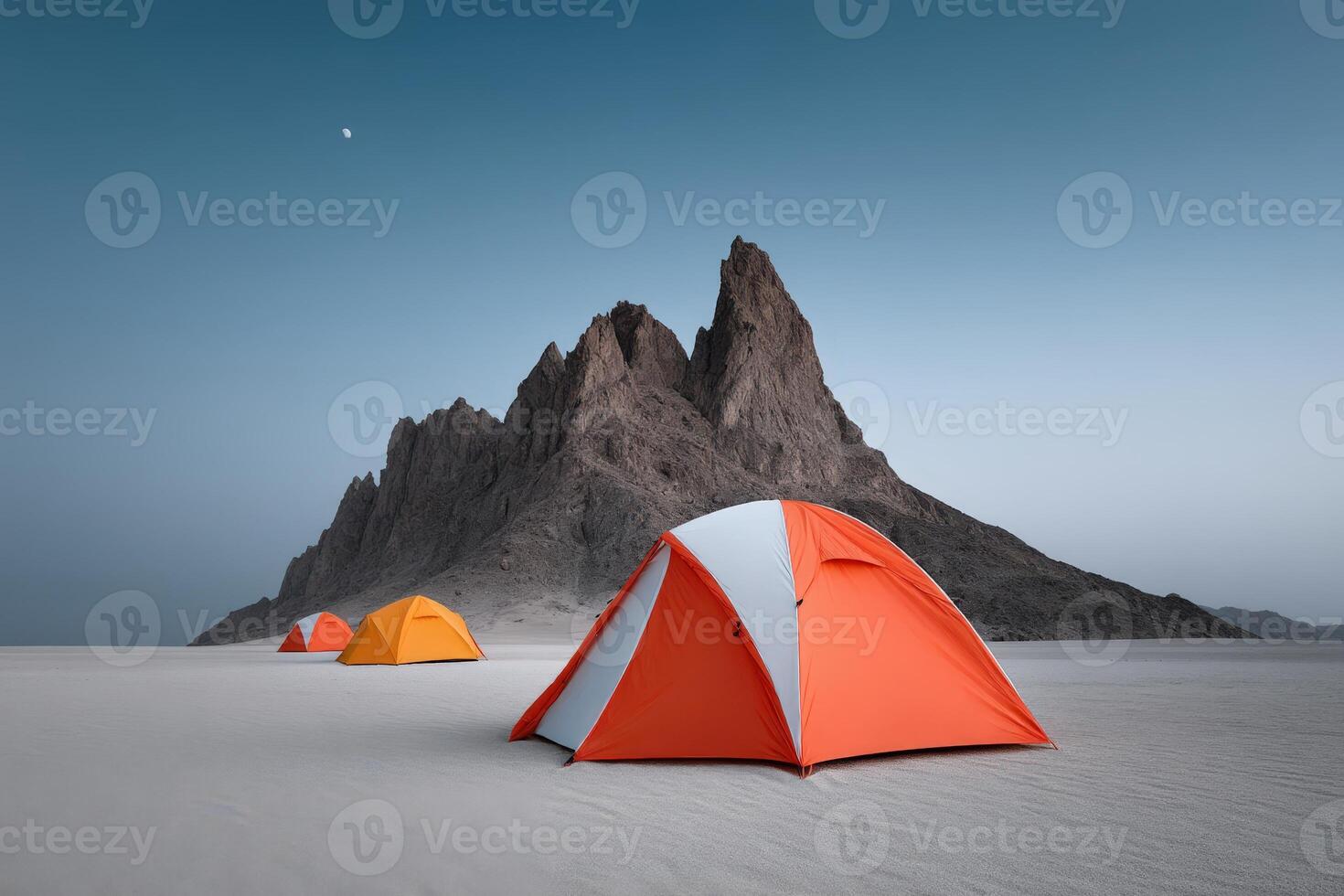 Night camping under a clear sky in a desert landscape with mountains photo