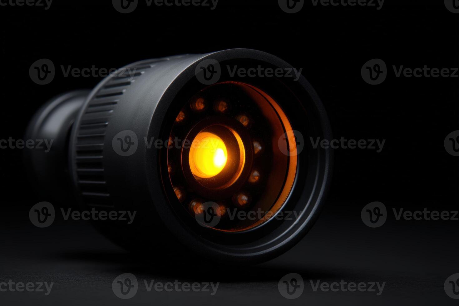 Night vision CCTV lens emits orange glow in low light setting for surveillance purposes photo
