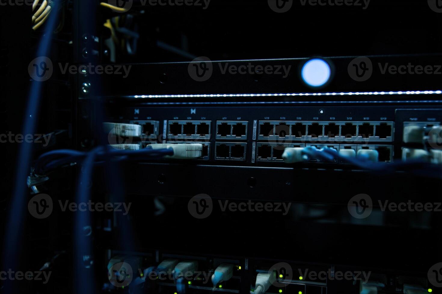 Networking rack with patch panel showing multiple cable connections and indicators photo