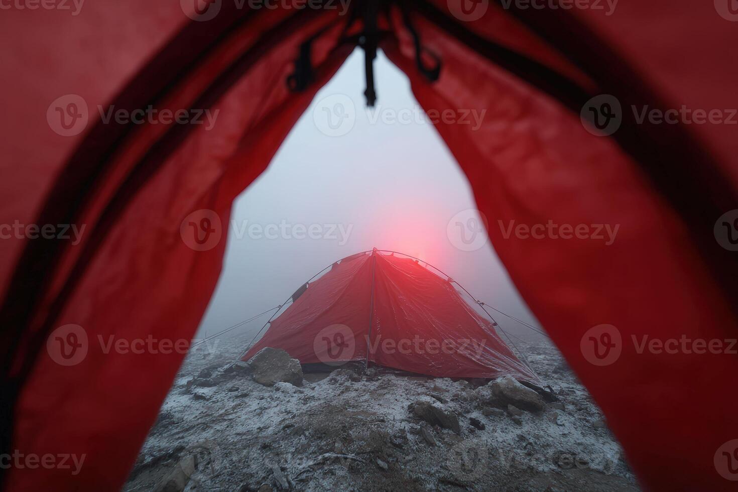 View from the inside of a red camping tent in misty mountain conditions at dawn photo