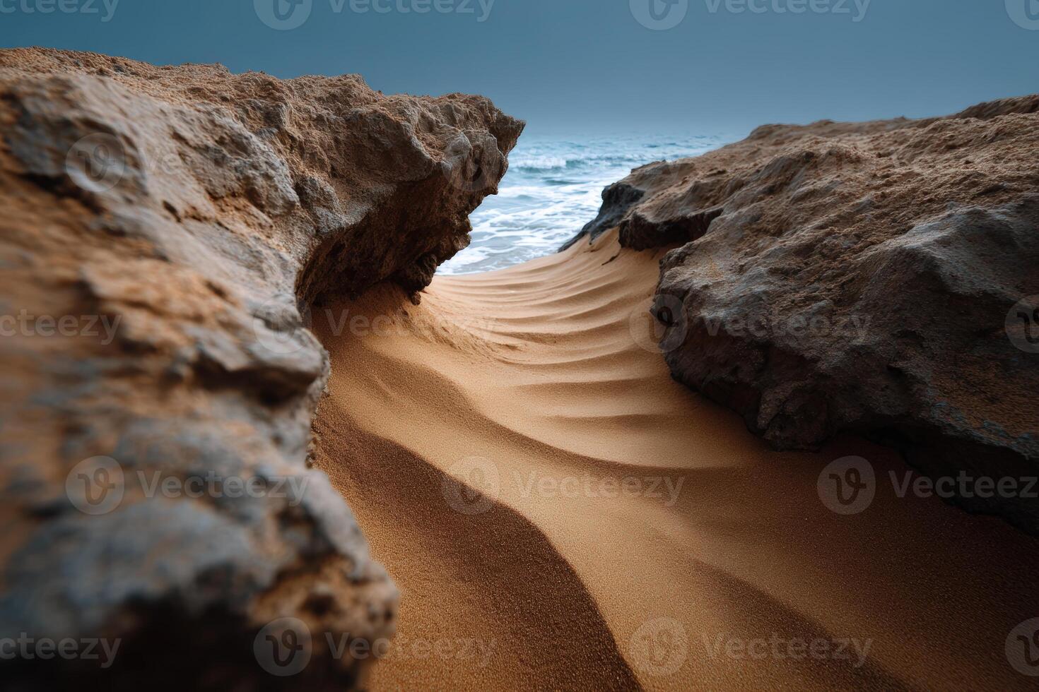 Waves of sand creating patterns in a rocky coastal inlet during twilight photo