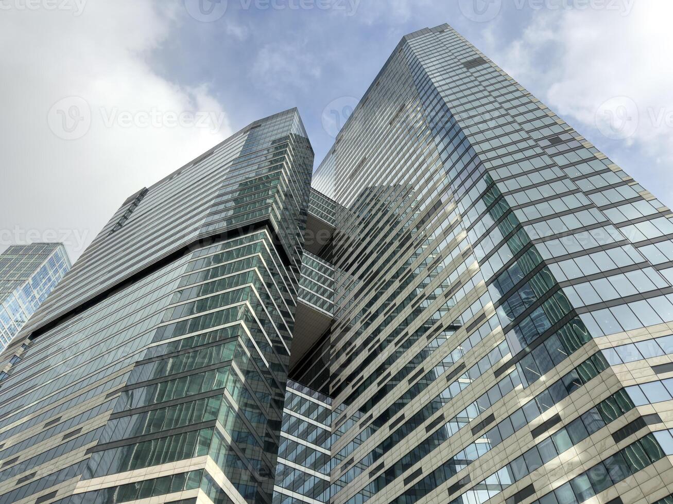 Glass skyscrapers with reflective surfaces reaching into the sky, symbolizing innovation, growth and the dynamic nature of contemporary urban architecture and business hubs photo