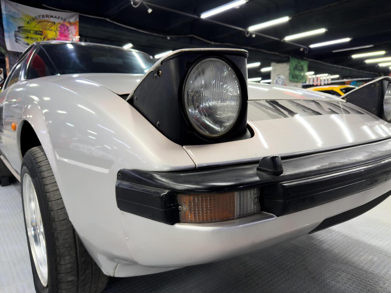 Moscow, Russia, April 27, 2025 Close-up of classic Mazda RX 7 SA22C showcasing its iconic pop up headlights, hallmark of retro Japanese automotive design and engineering photo
