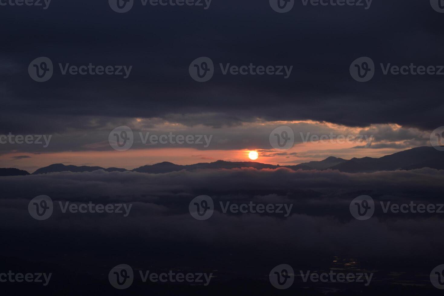 A view of the sun setting over the mountains photo