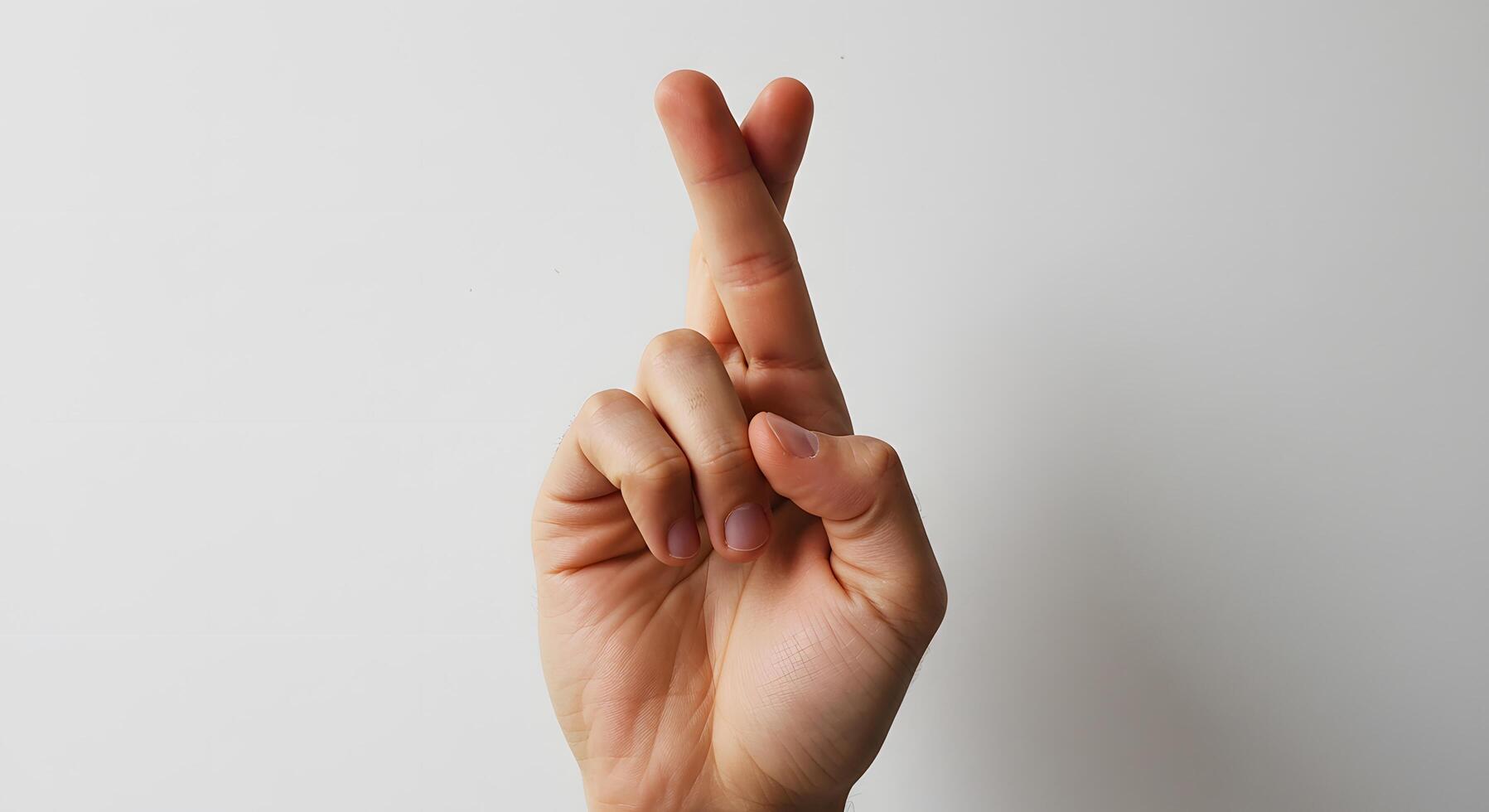 Fingers crossed, A left hand with fingers crossed, isolated on a clean white background, symbolizing hope or good luck photo