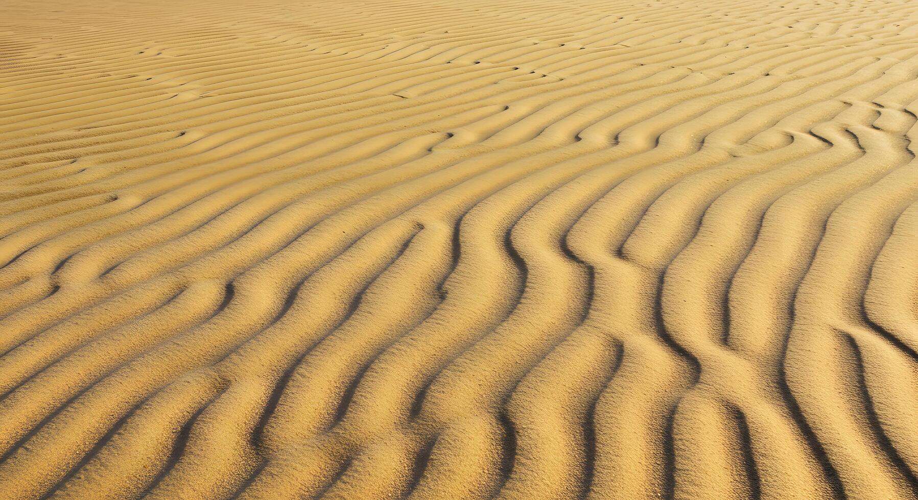 Close-up of beach sand with rippled surface, designed for calming digital wallpapers, vacation ads, or earthy product displays. photo