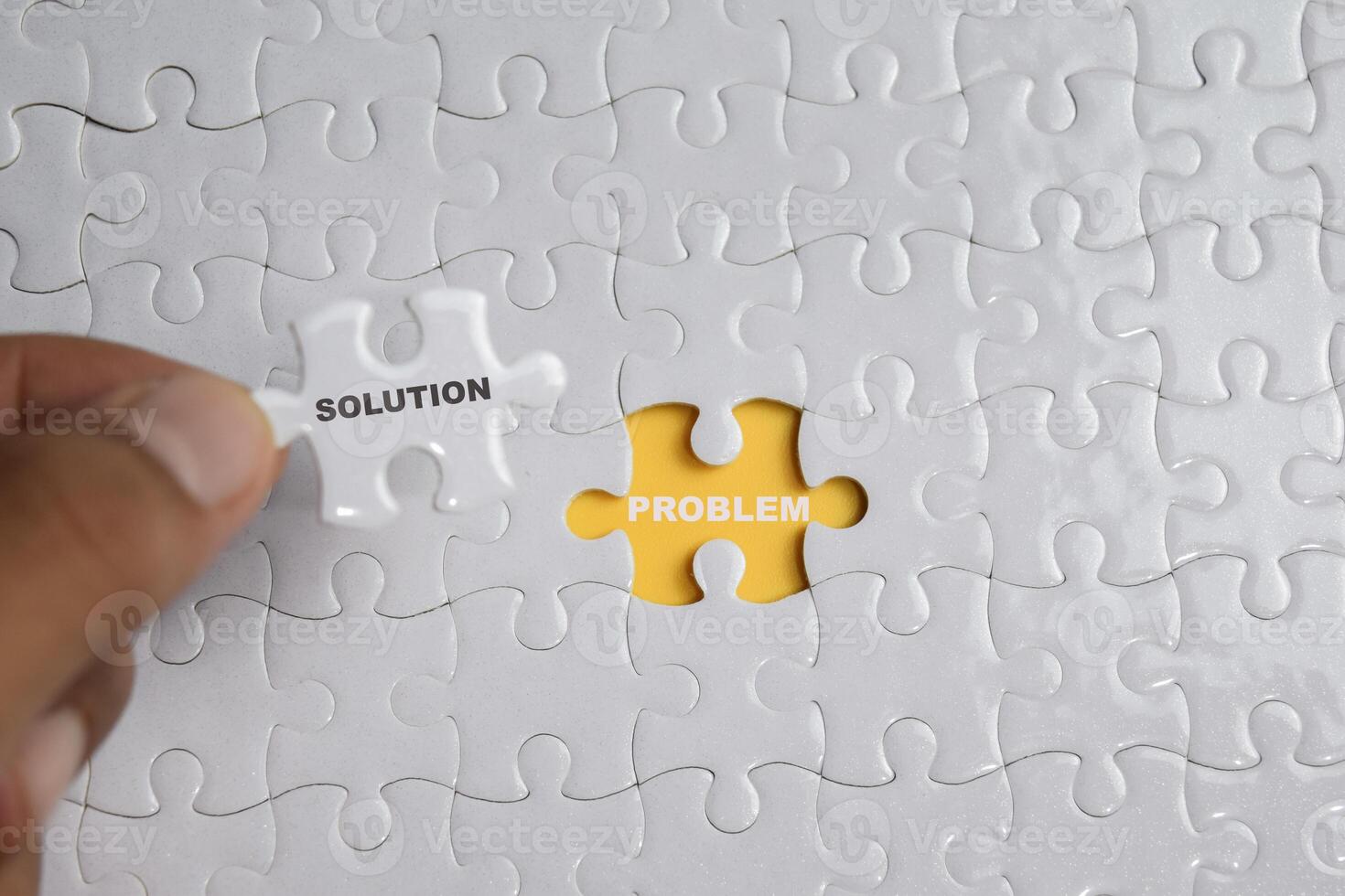 Hand holding piece of jigsaw puzzle with word solution problem. Business and finance concept photo