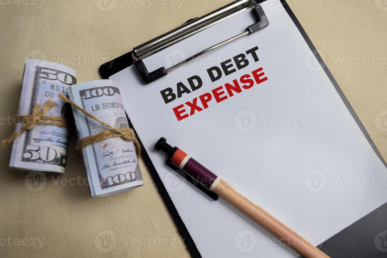 Concept of Bad debt expense write on clipboard isolated on Wooden Table. photo