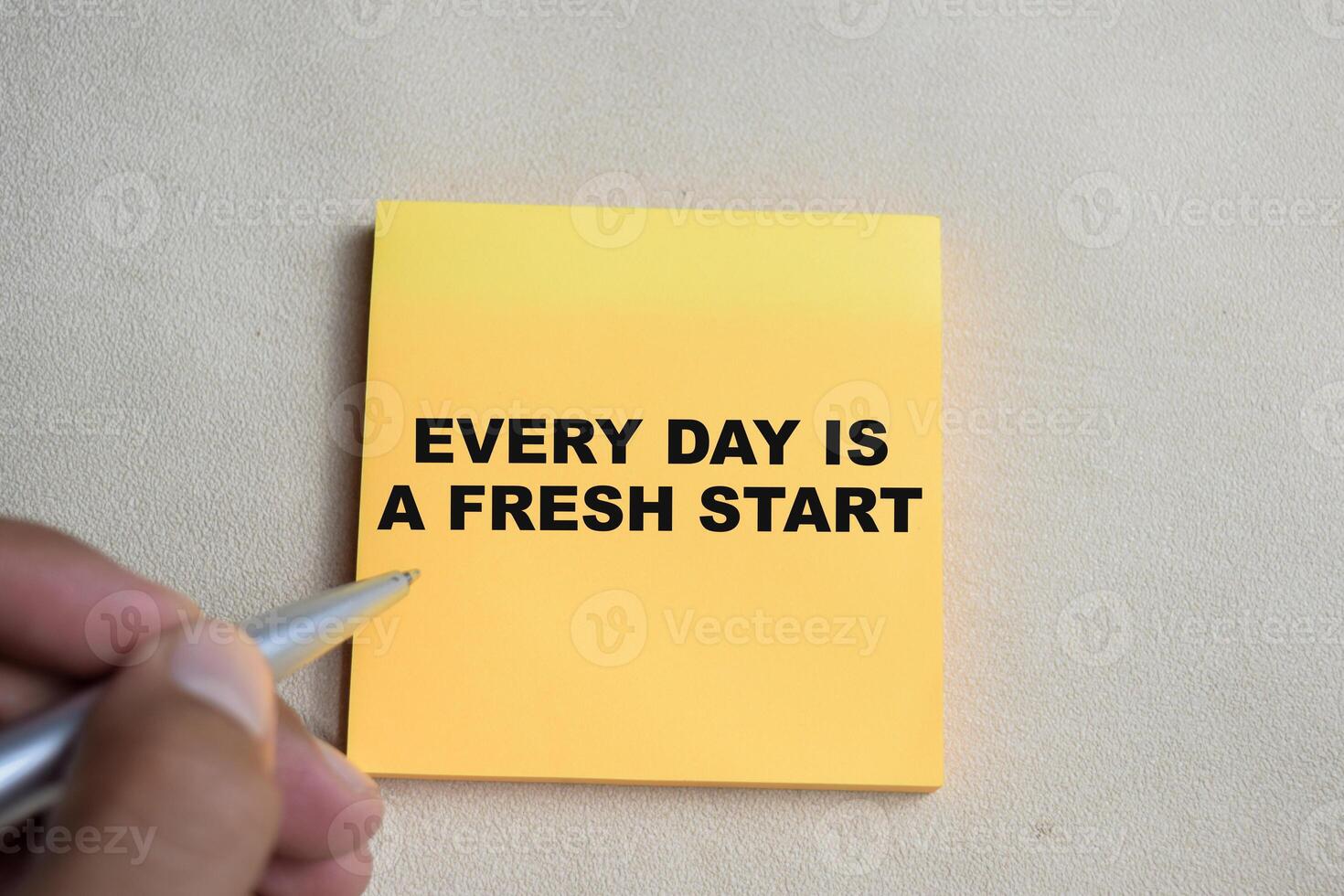 Concept of Every day is a fresh start write on sticky notes isolated on Wooden Table. photo