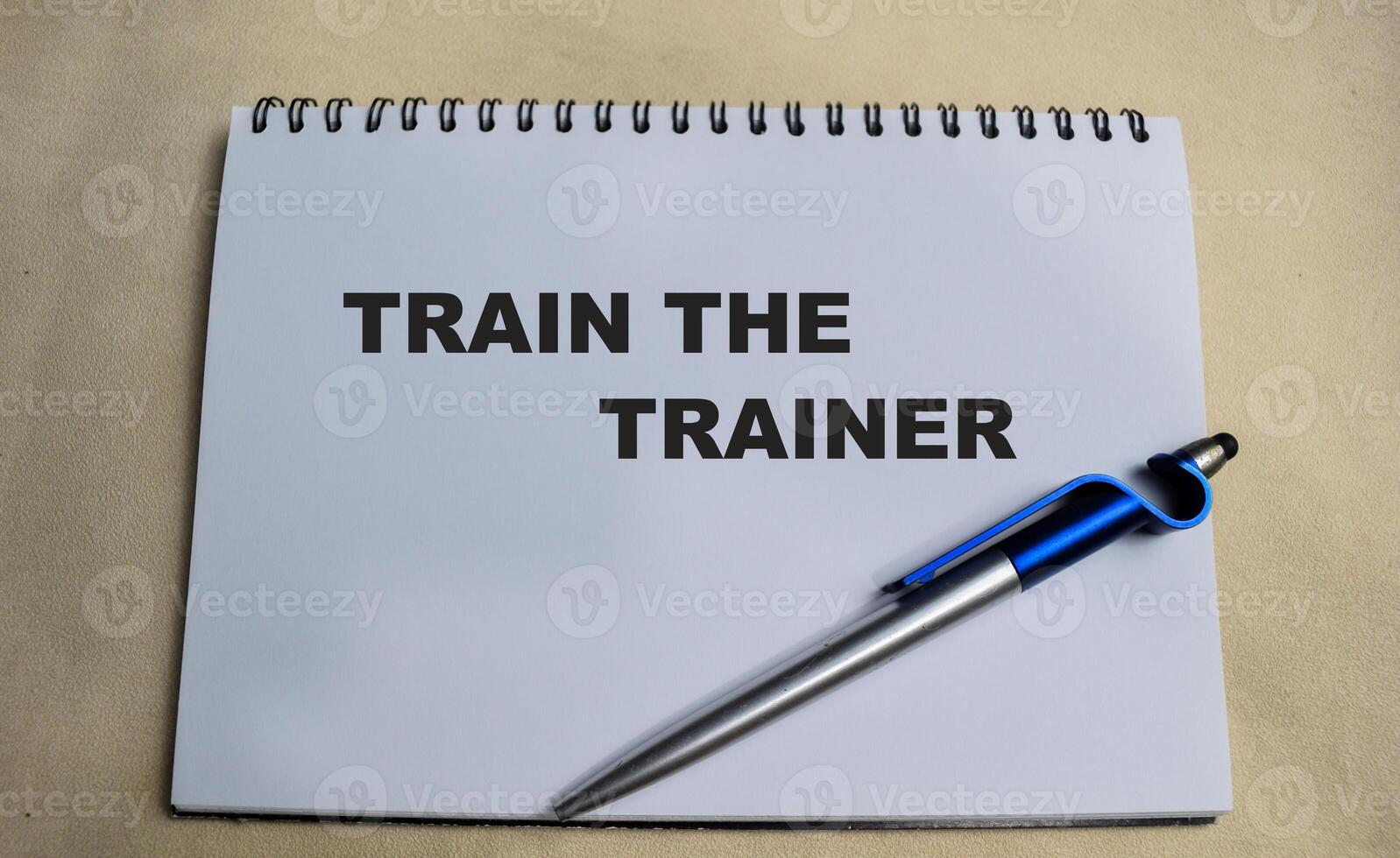 Concept of Train the trainer write on book isolated on Wooden Table. photo