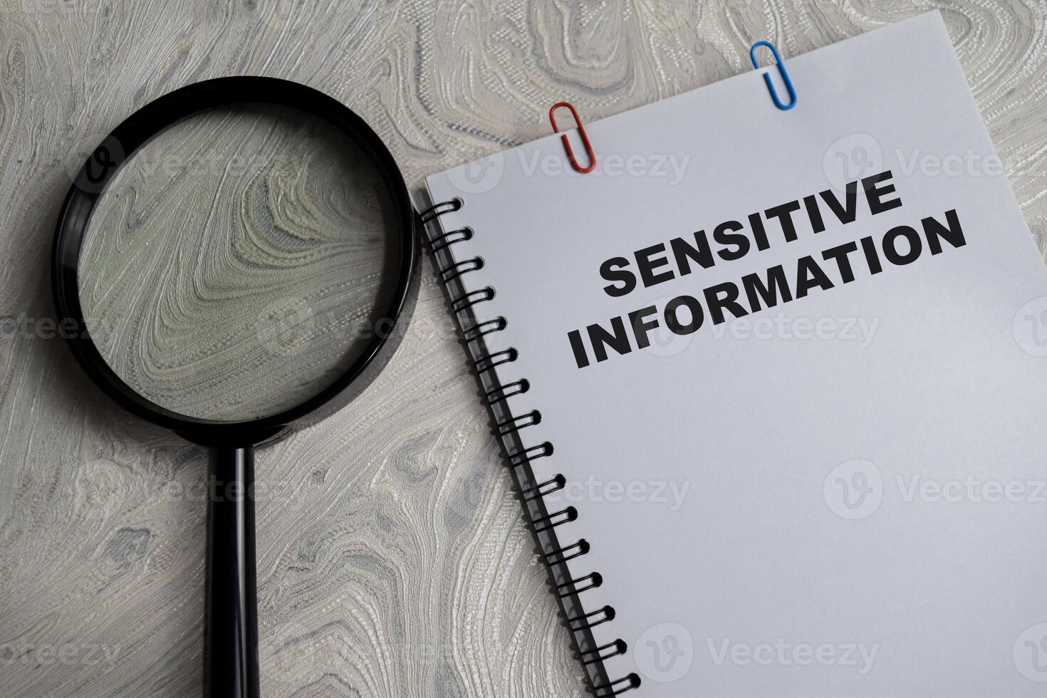Concept of Sensitive information write on book isolated on Wooden Table. photo