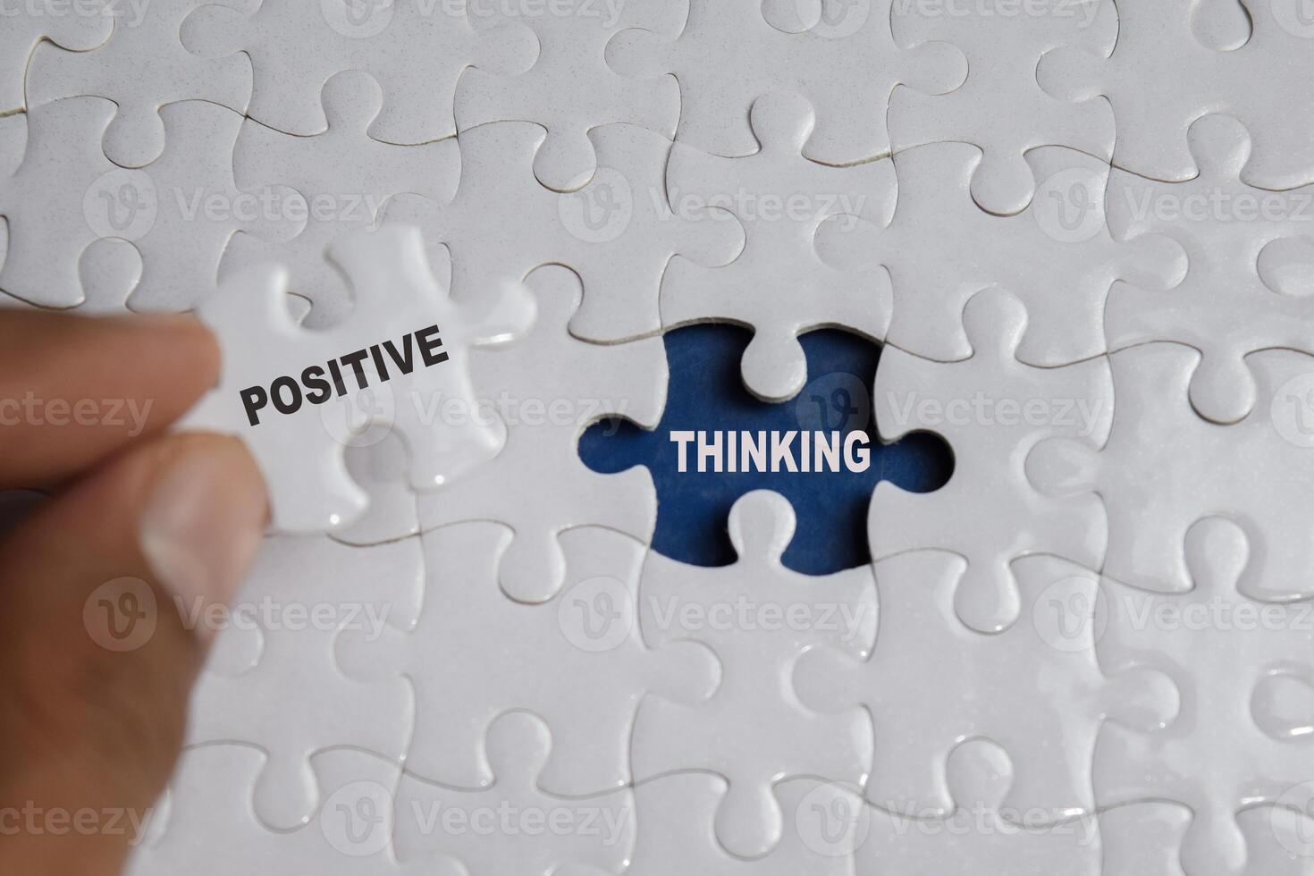 Hand holding piece of jigsaw puzzle with word Positive thinking. Business and finance concept photo