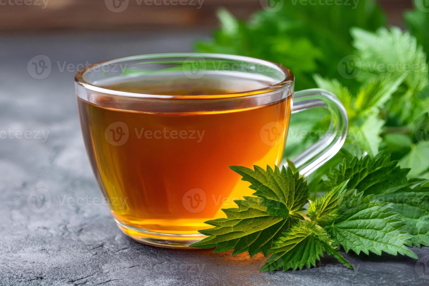 Herbal tea with fresh nettle leaves in glass cup on table photo