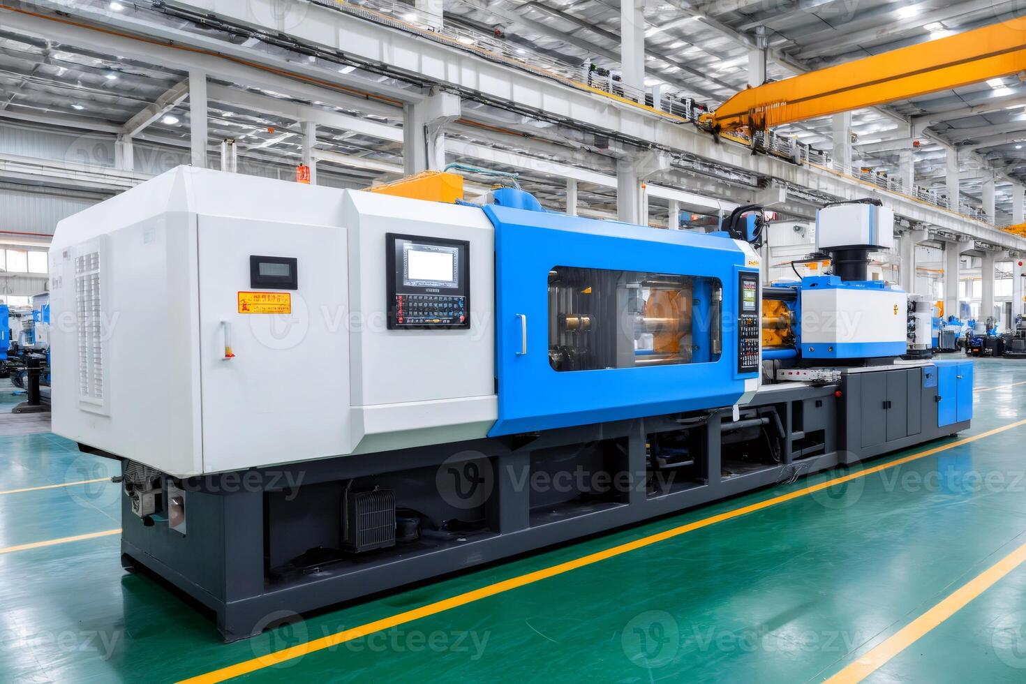 Modern plastic injection molding machine operating in a factory photo