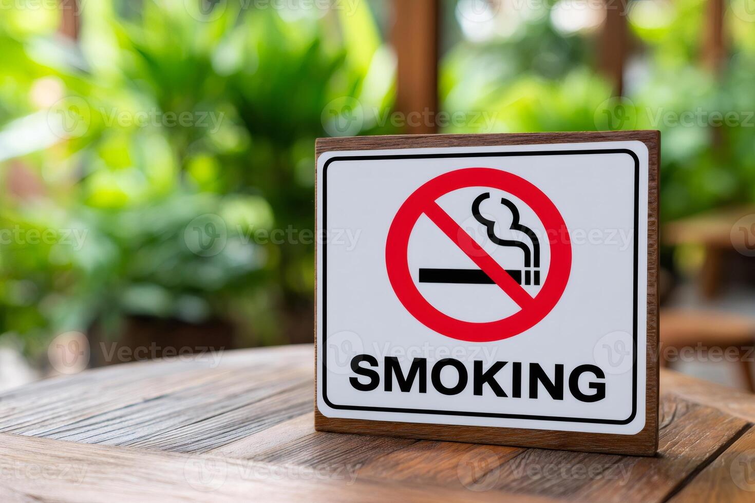 No smoking sign stands on table in blurred green garden background photo