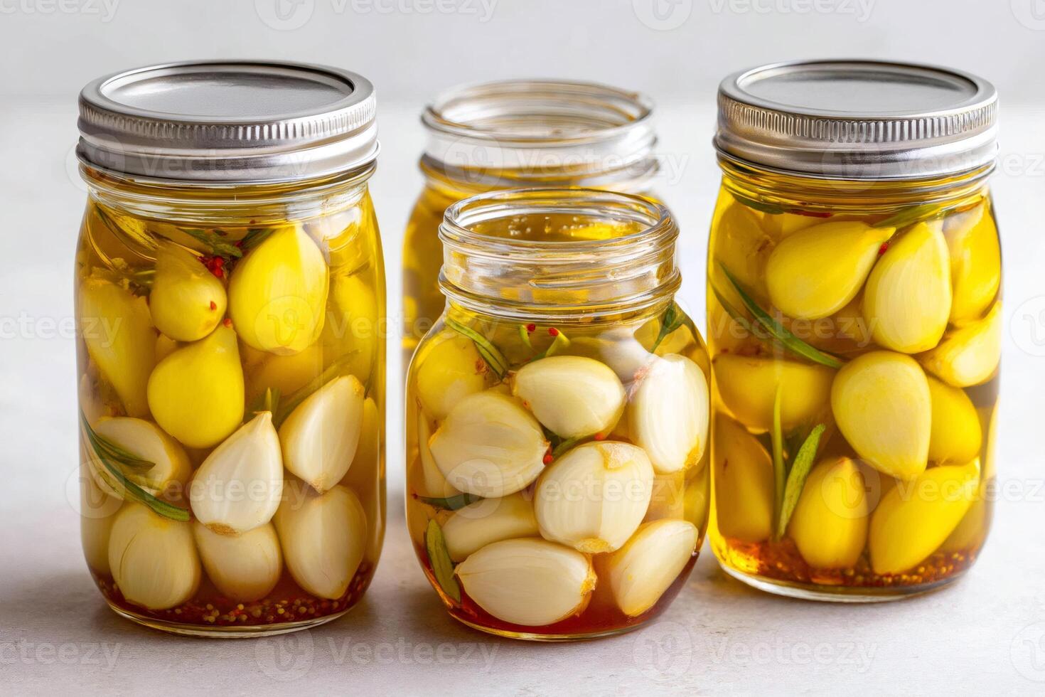 Preserved garlic cloves and bulbs in oil with rosemary and spices photo