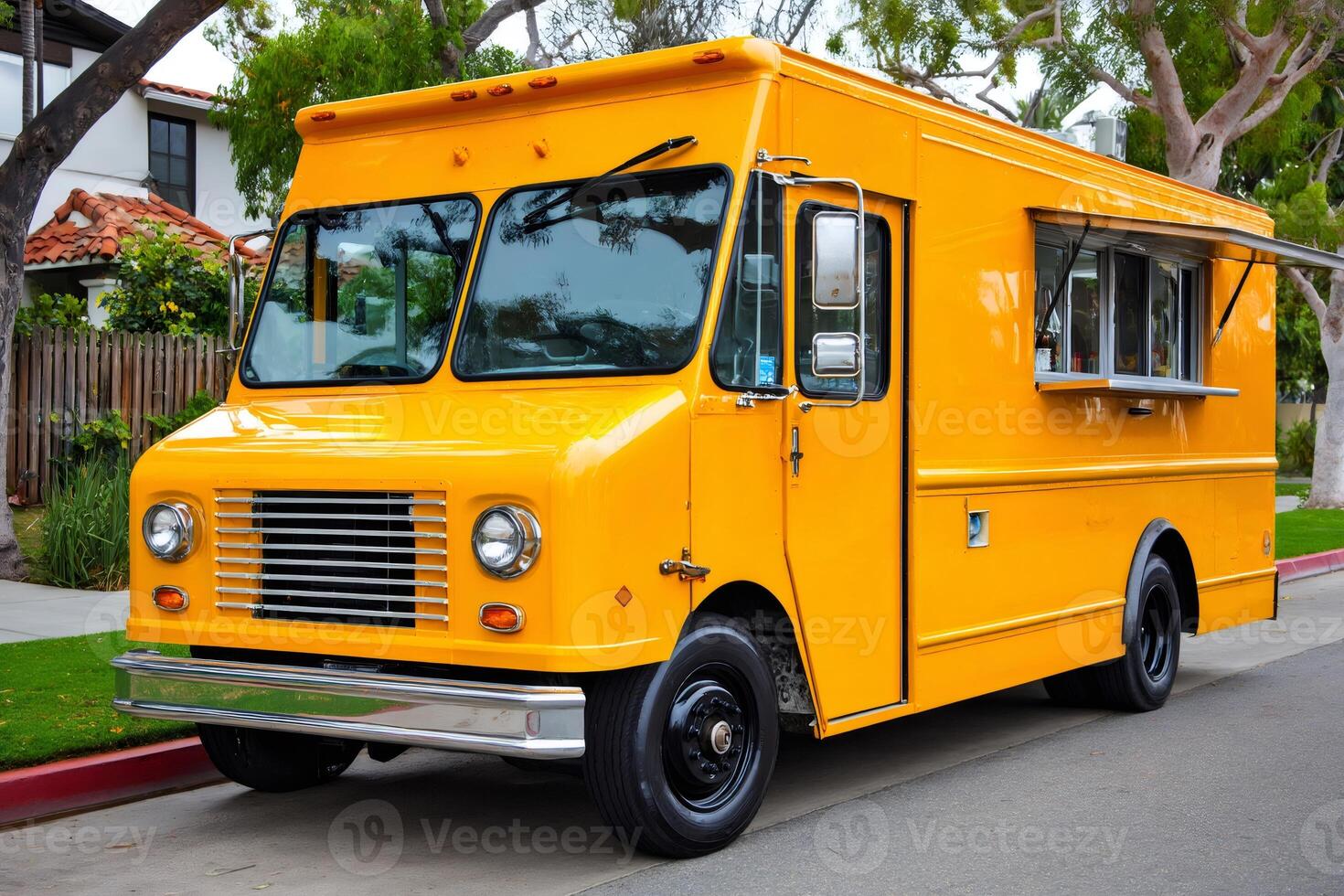 Bright yellow food truck parked on suburban street offering delicious meals photo