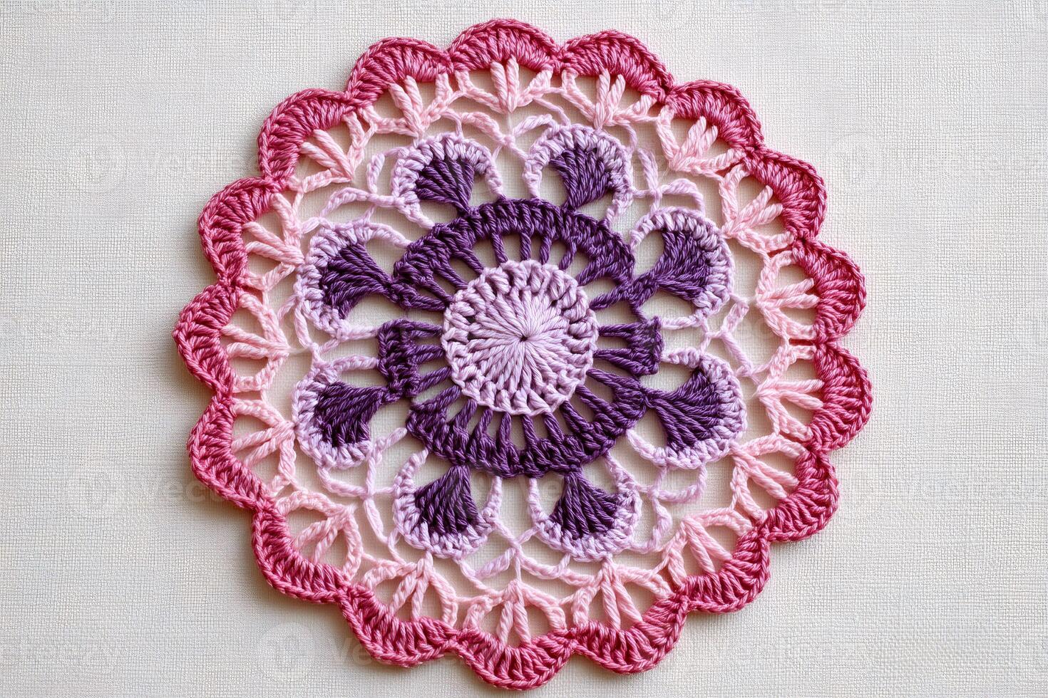 Beautiful pink and purple crochet doily showing delicate handmade craftsmanship photo