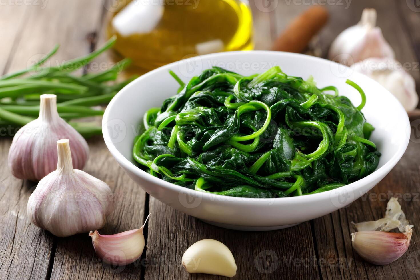 Steamed spinach with garlic and olive oil on rustic wooden table photo