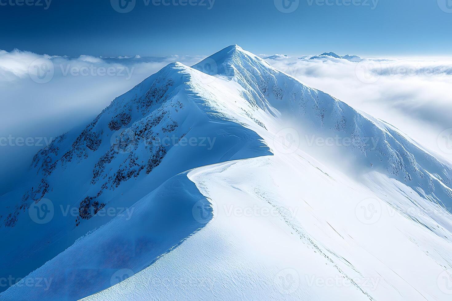 Majestic Winter Landscape of Snow-Capped Mountain Peaks in Serene Blue Sky photo