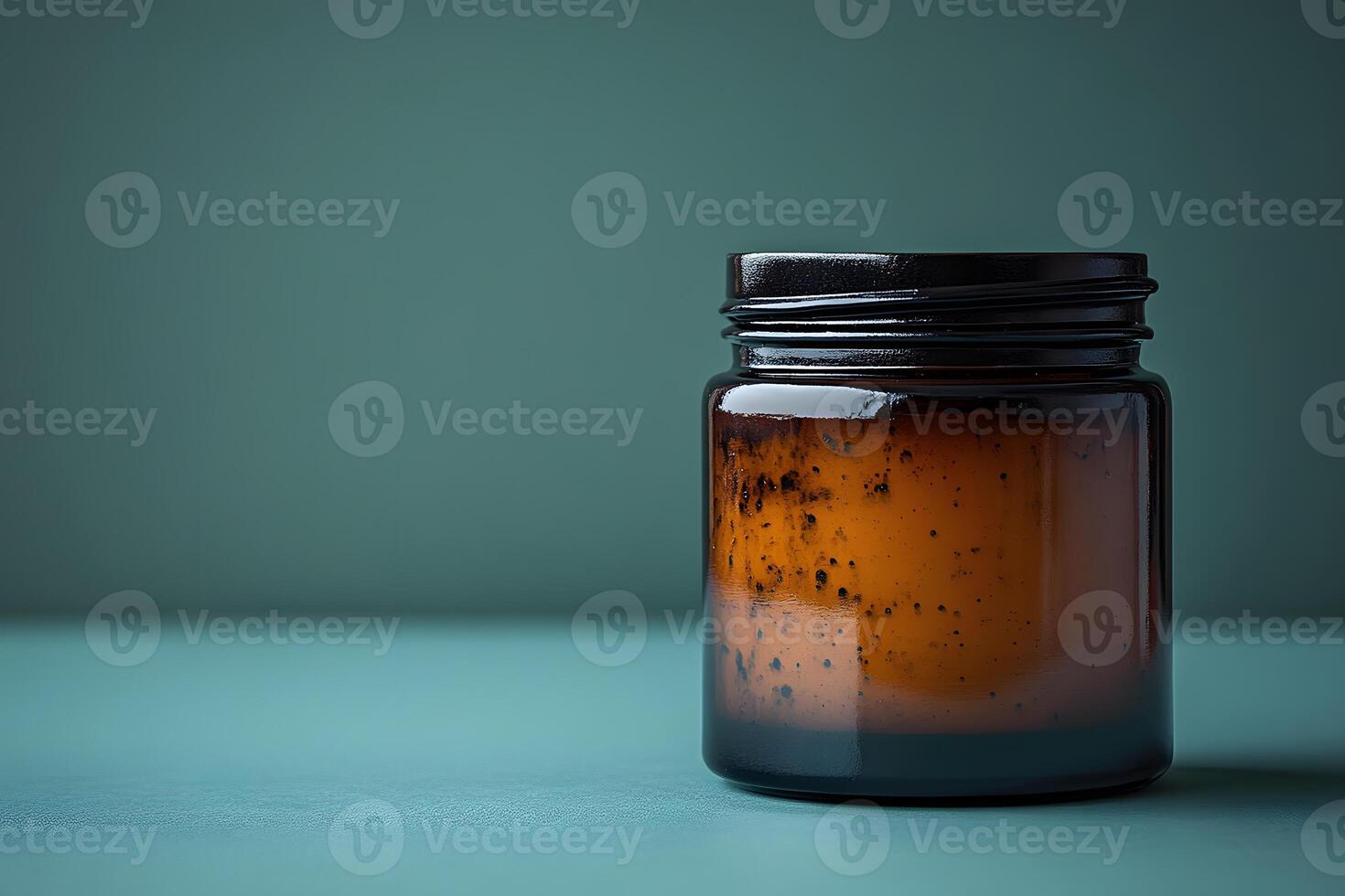 Minimalist Amber Glass Jar on Teal Background for Skincare Product Display photo