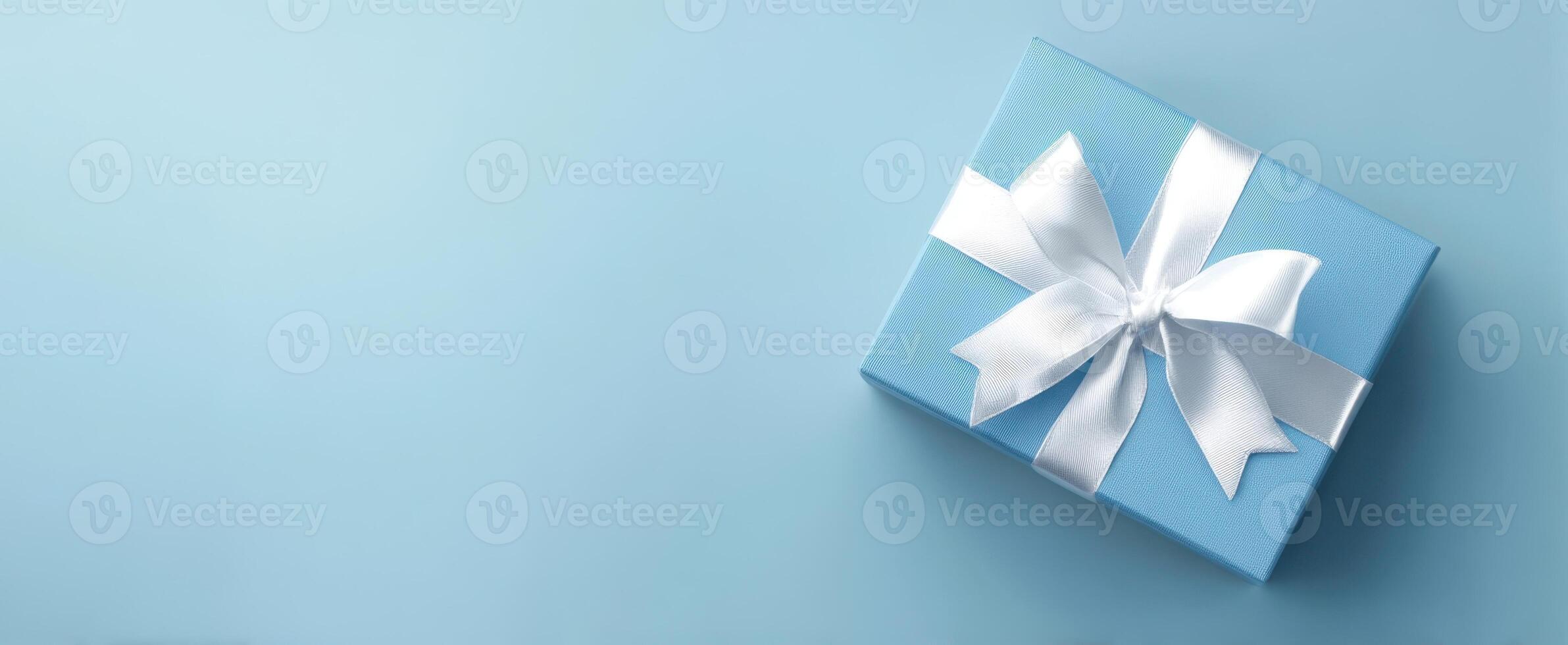 The elegant blue gift box with white ribbon on a soft background. photo