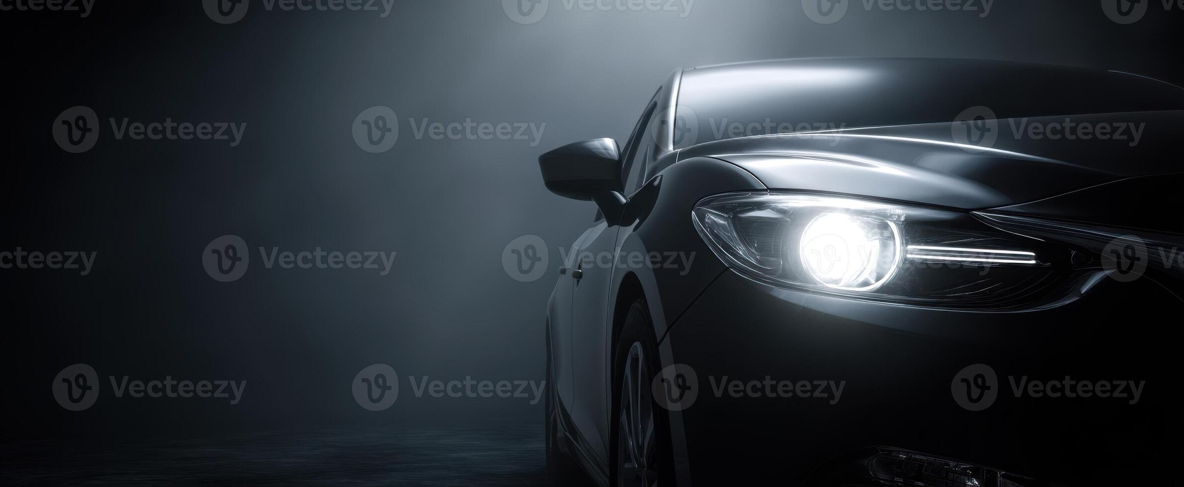 The sleek black car illuminated by dramatic headlights in a dark atmosphere. photo
