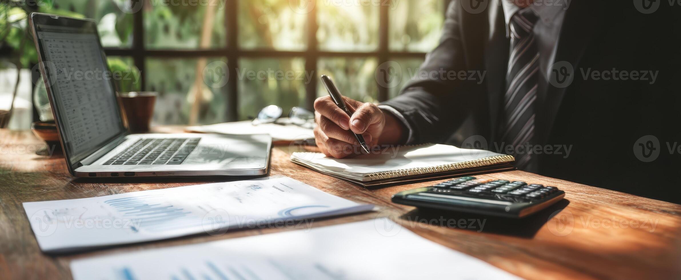 The business professional writing in a notebook at an organized office desk. photo