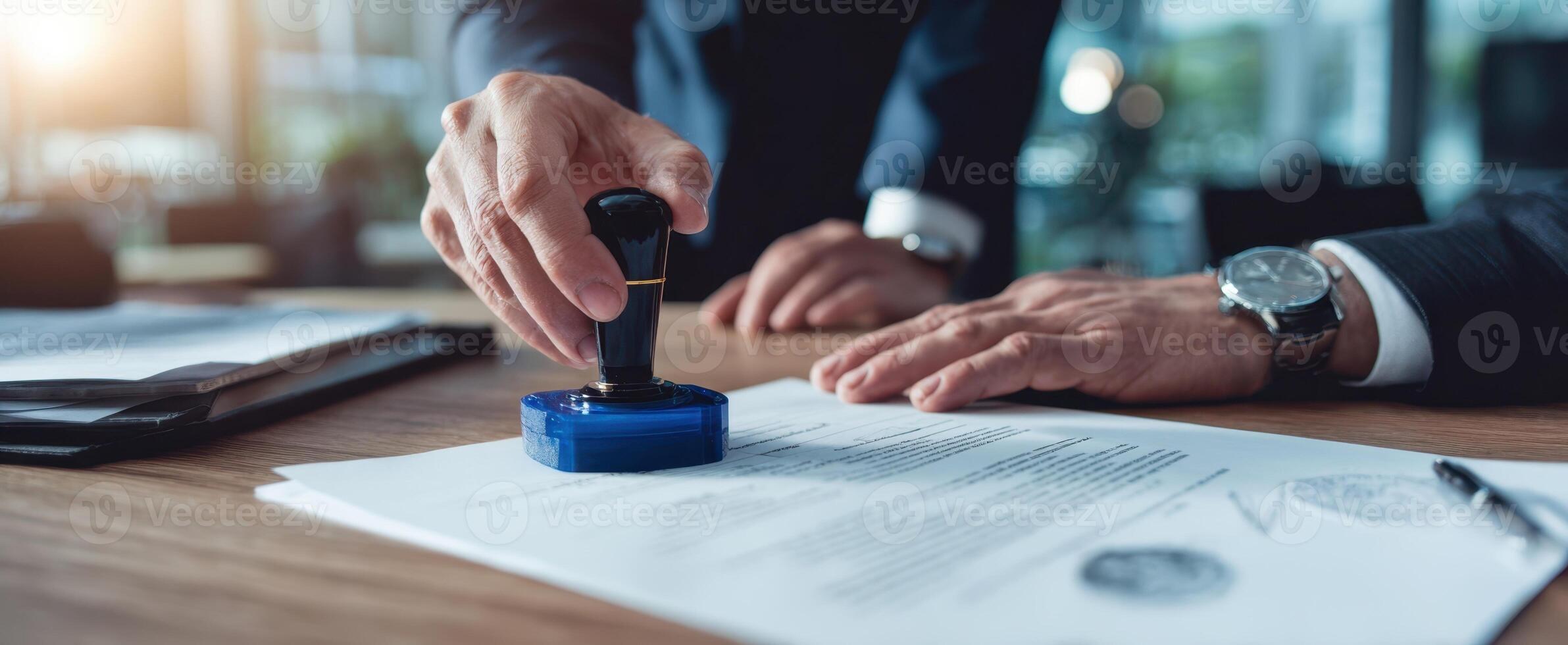 The businessman applying a seal to important legal documents on his desk. photo