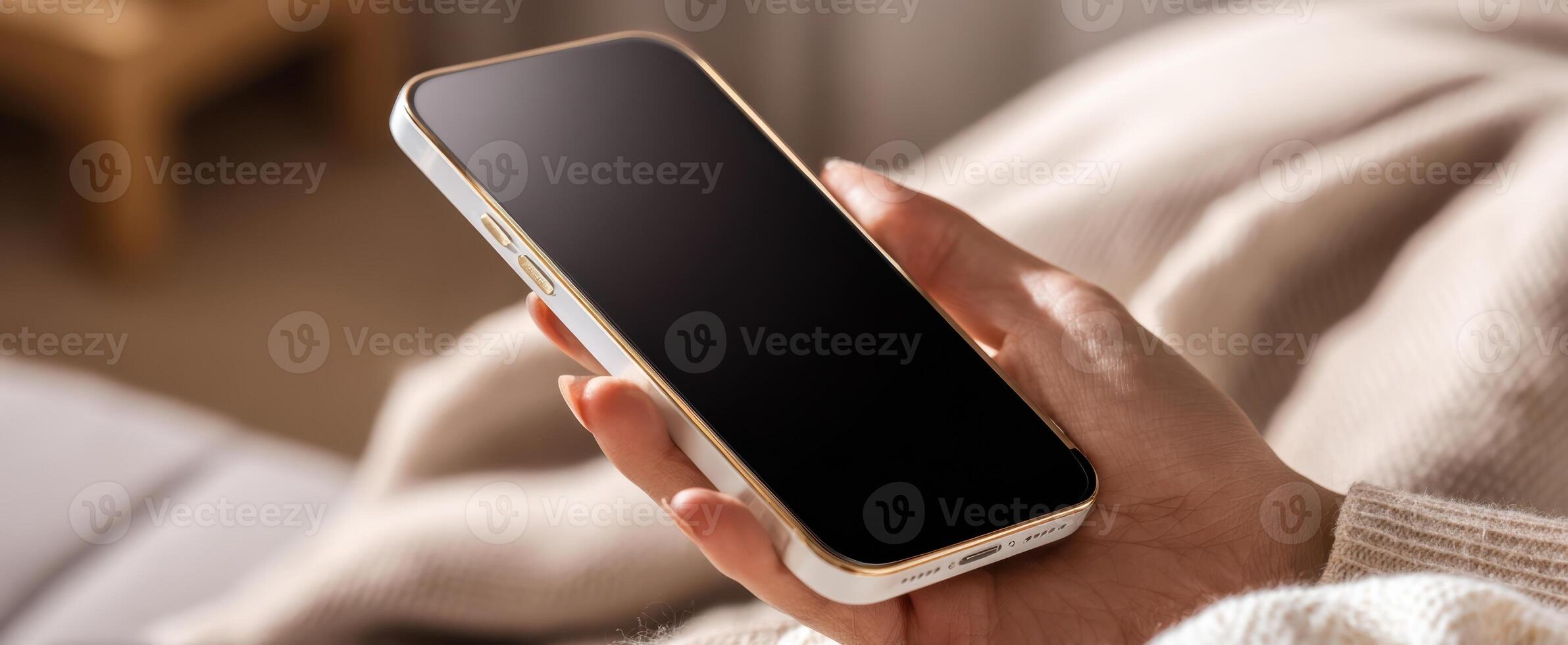 The modern smartphone held in a cozy, inviting environment. photo