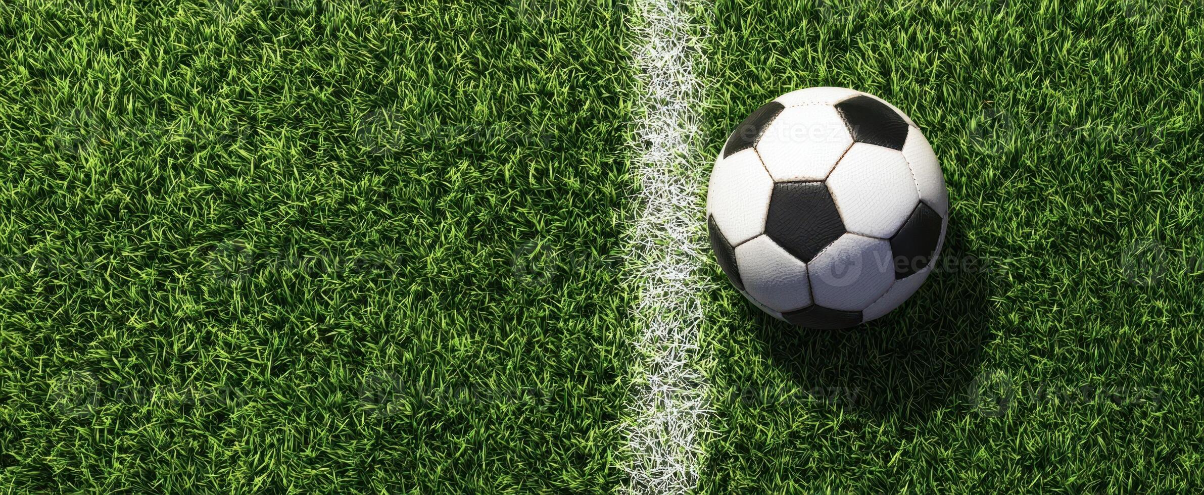 The soccer ball positioned on the vibrant green turf of a field. photo