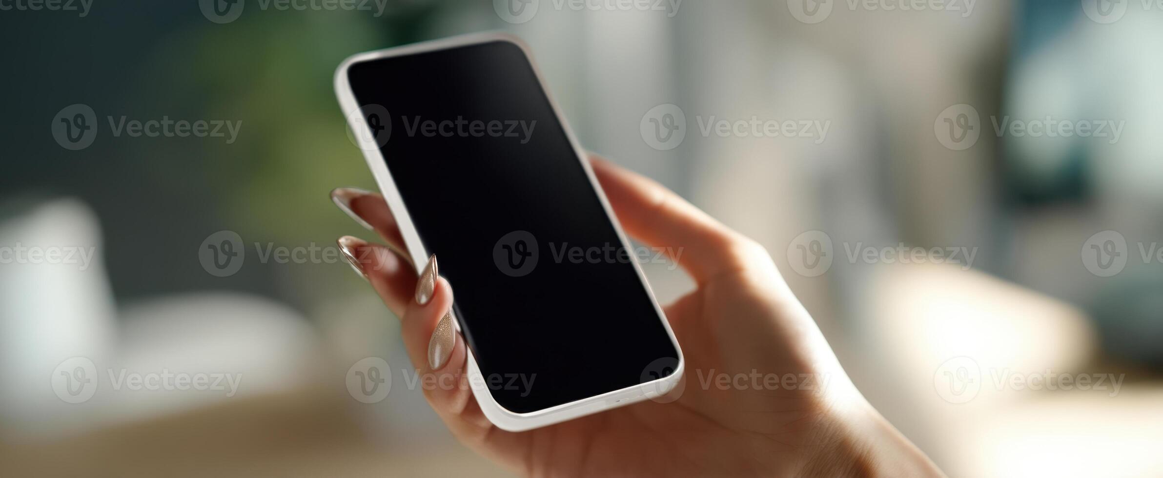 The smartphone held in a hand with a blurred background setting photo
