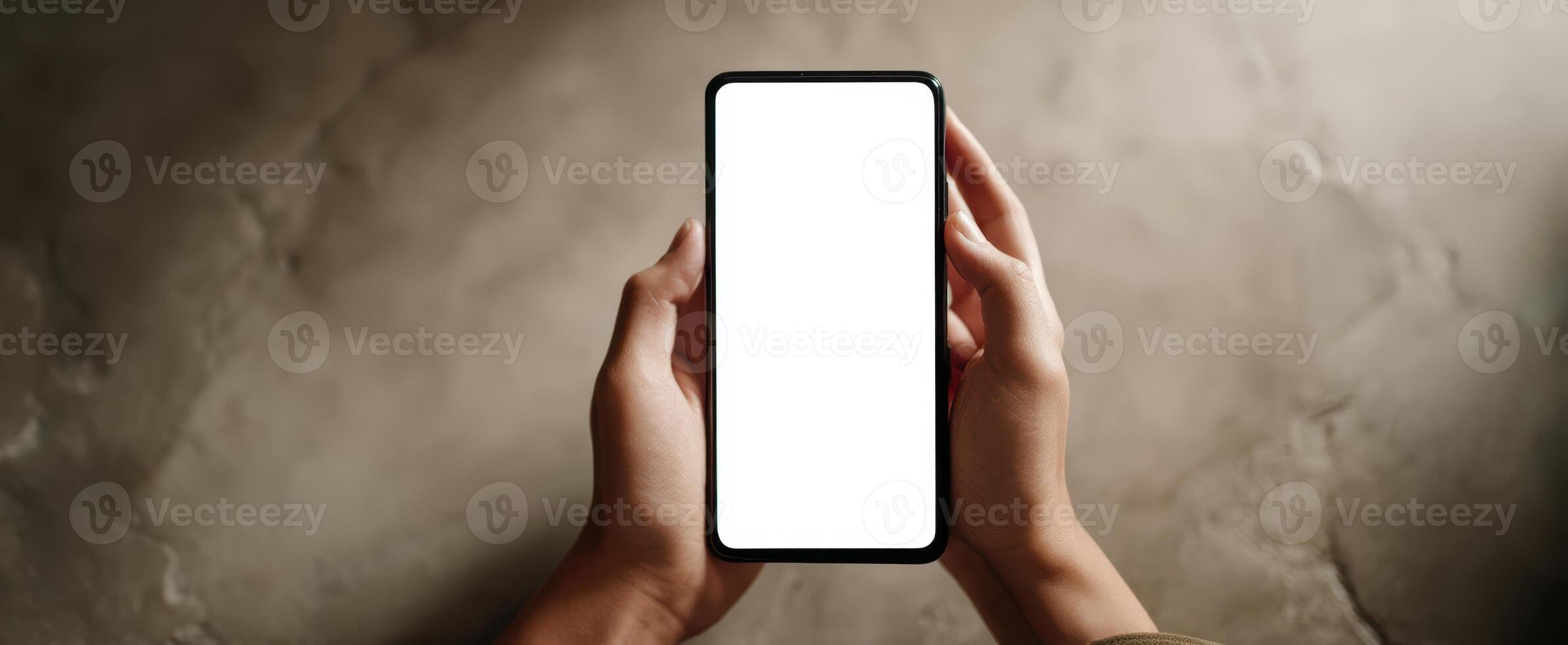 The smartphone held by hands showcasing a blank, empty screen for mockup use. photo