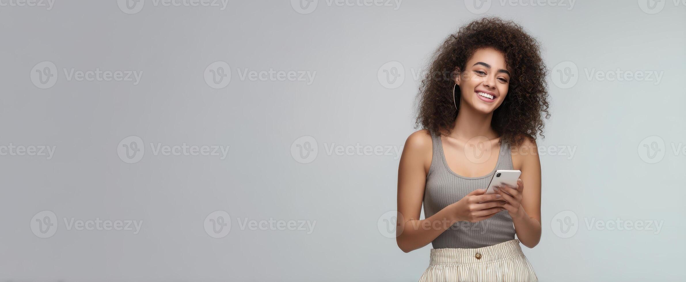 The woman smiling and using a smartphone in a casual setting. photo