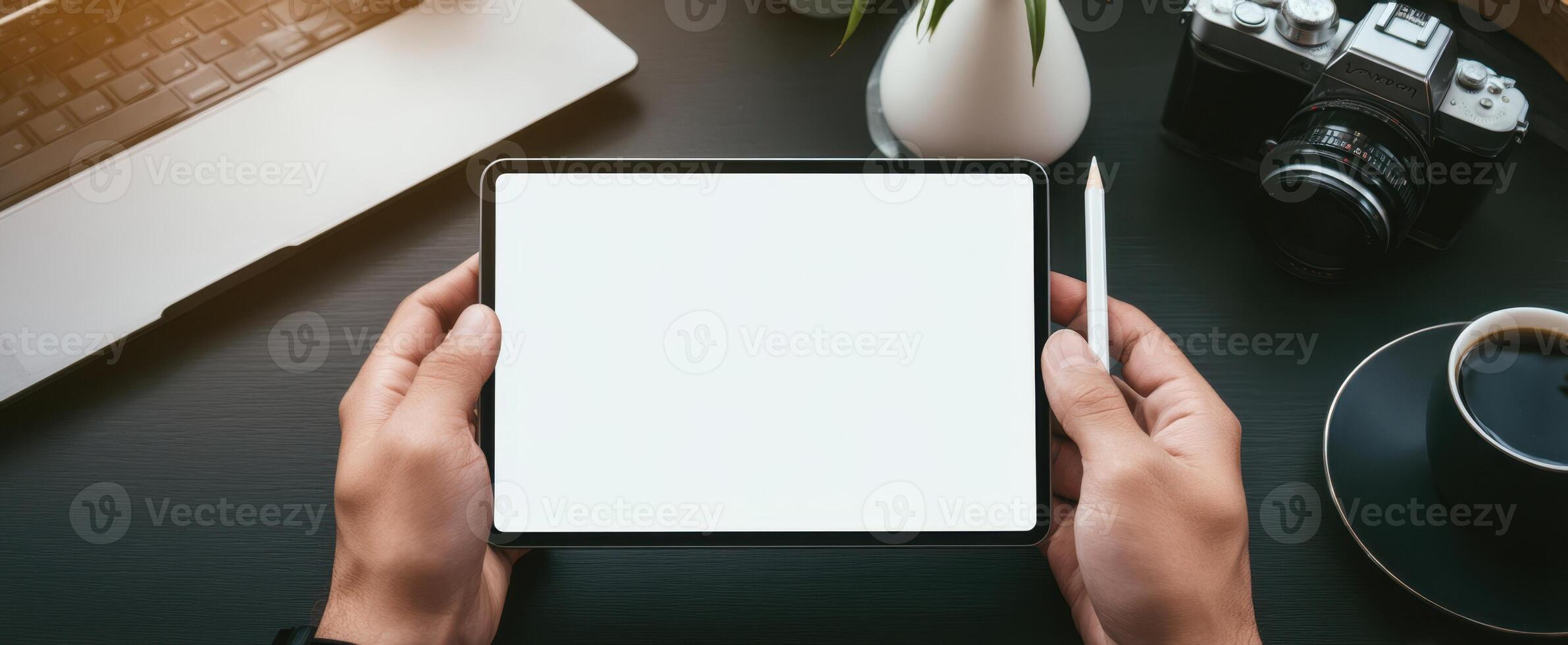The tablet held in hands with a minimalistic workspace background. photo