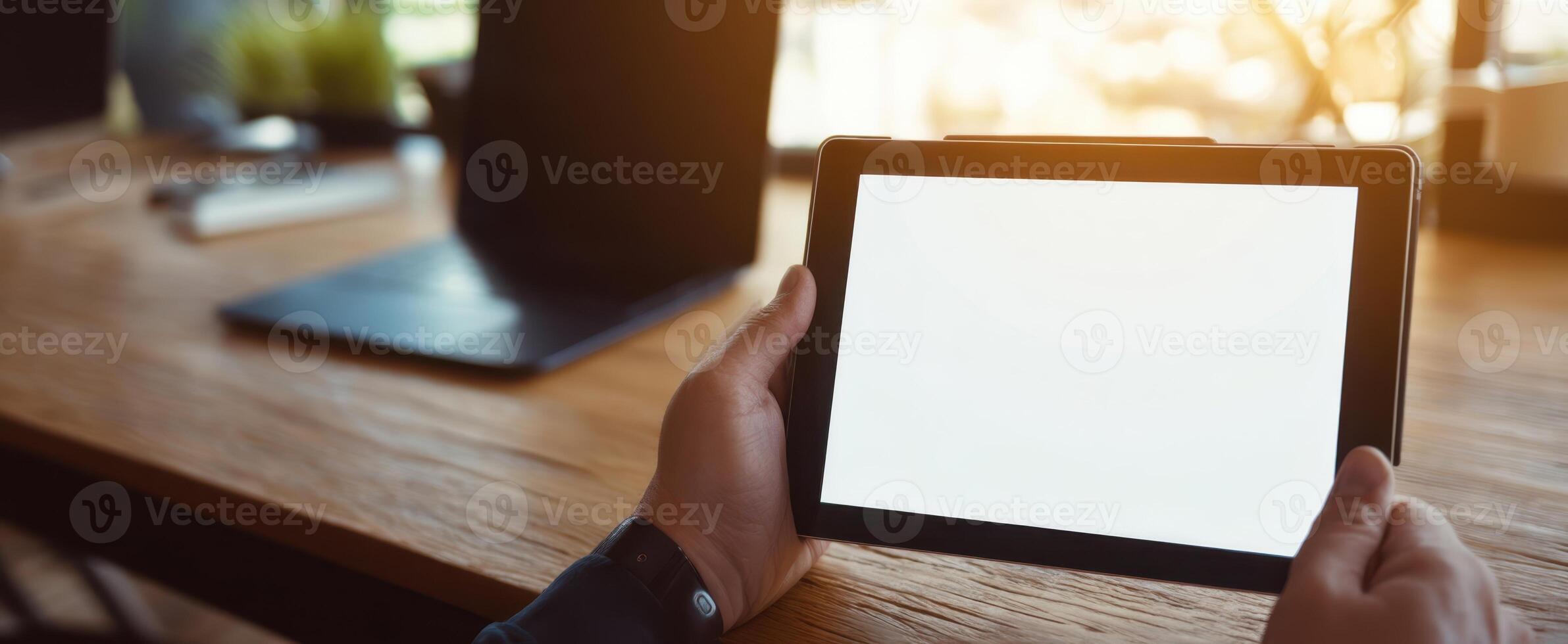 The modern tablet held in hands with a blank screen in an office setting. photo