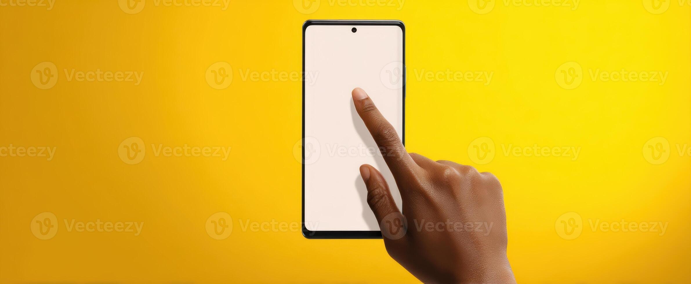 The smartphone interacting with a user's hand against a vibrant yellow background. photo
