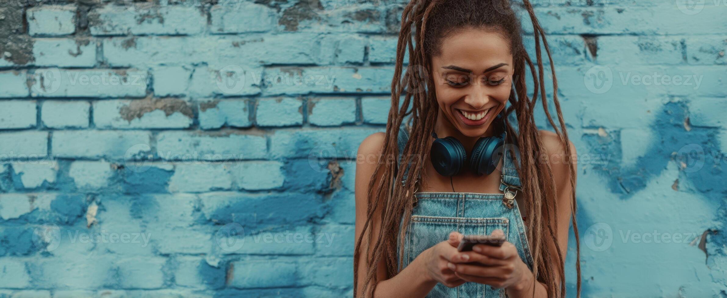 The joyful young woman enjoying music while texting on her smartphone. photo