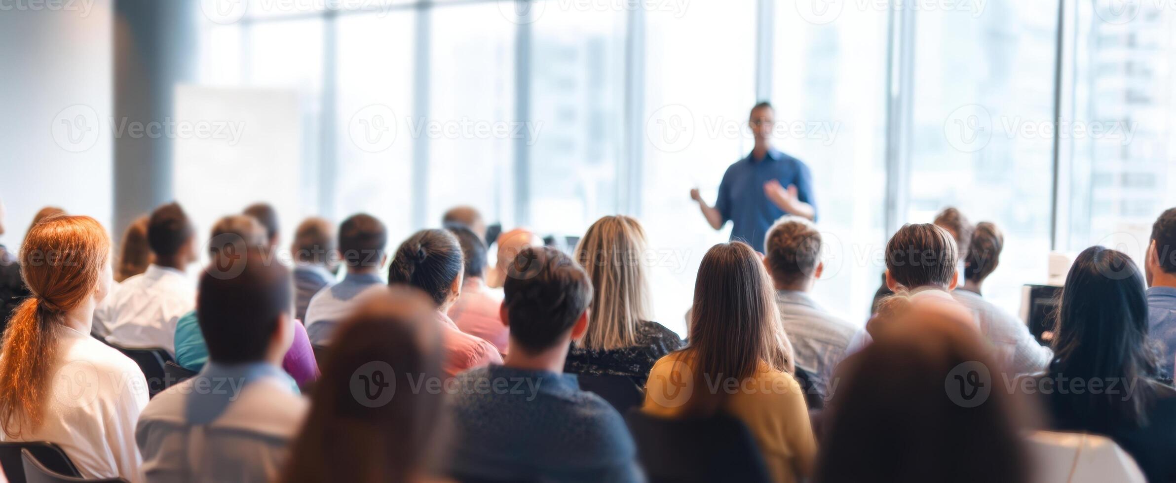 The speaker engaging an attentive audience during a professional seminar or workshop. photo