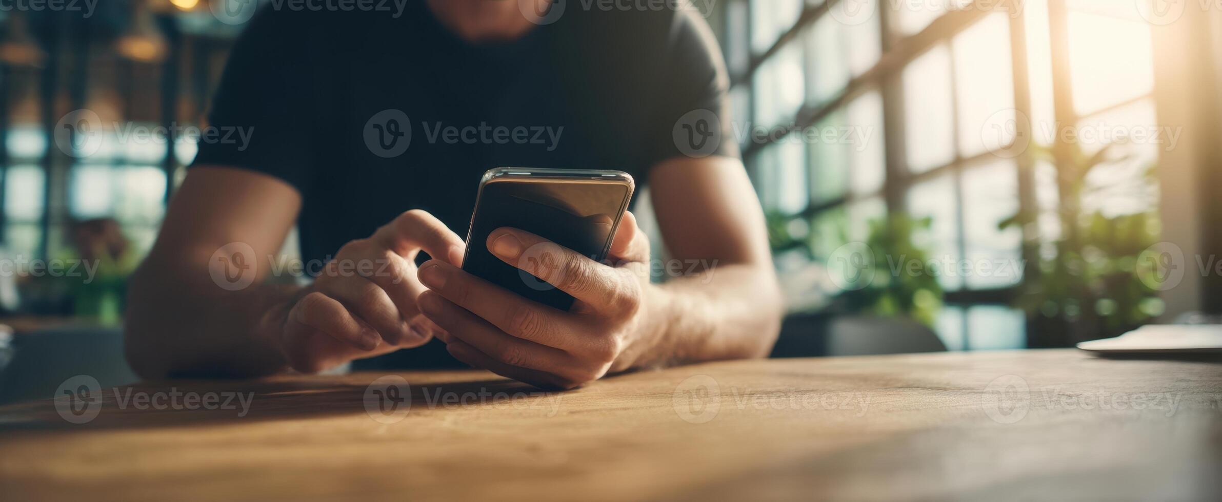 The person interacting with a smartphone while sitting at a wooden table. photo