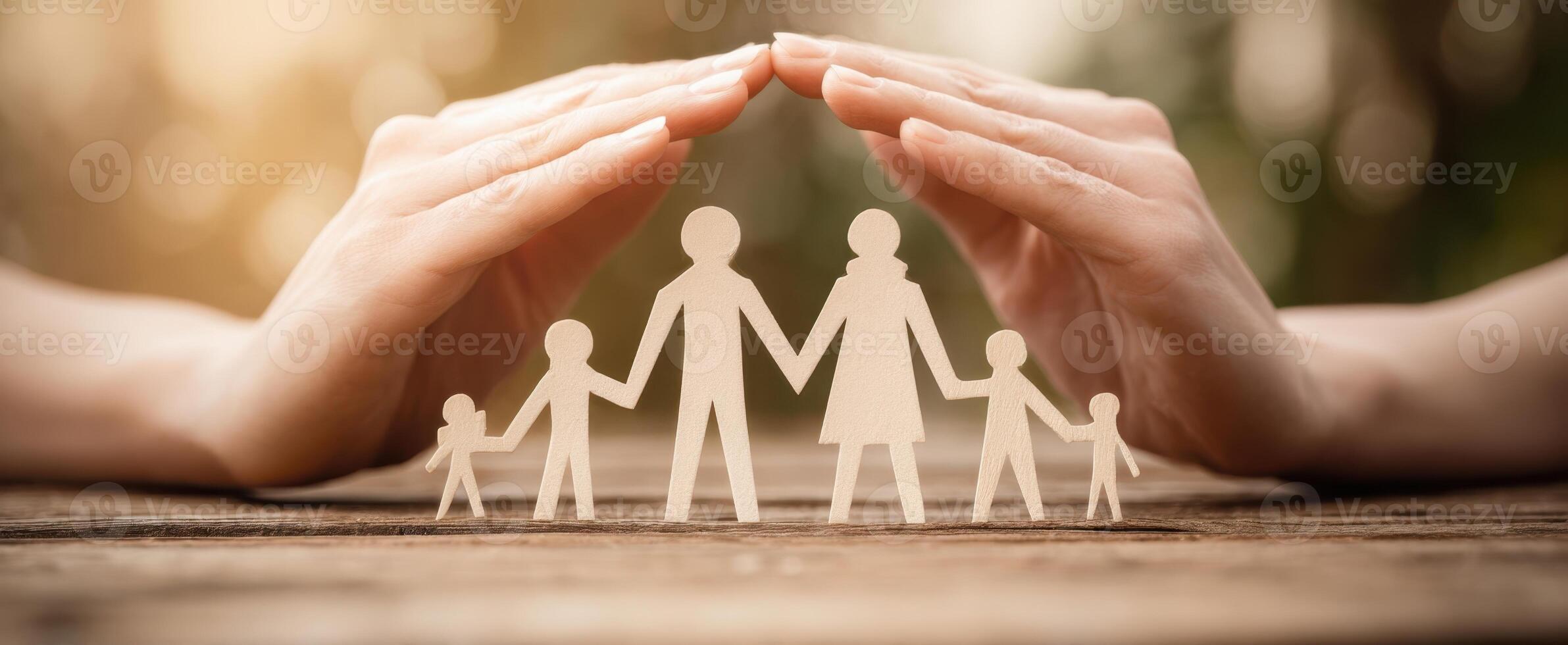 The hands protecting a paper family symbolizing love and unity. photo