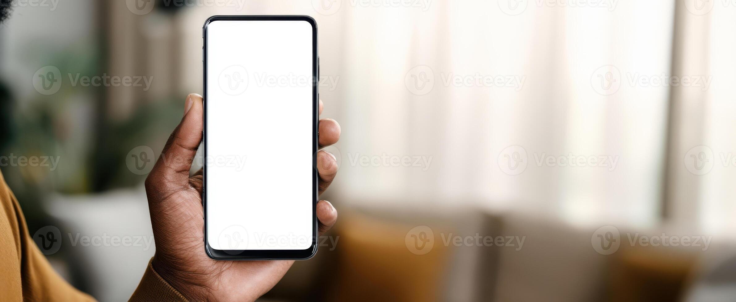 The smartphone held by a person in a cozy indoor setting with soft lighting. photo
