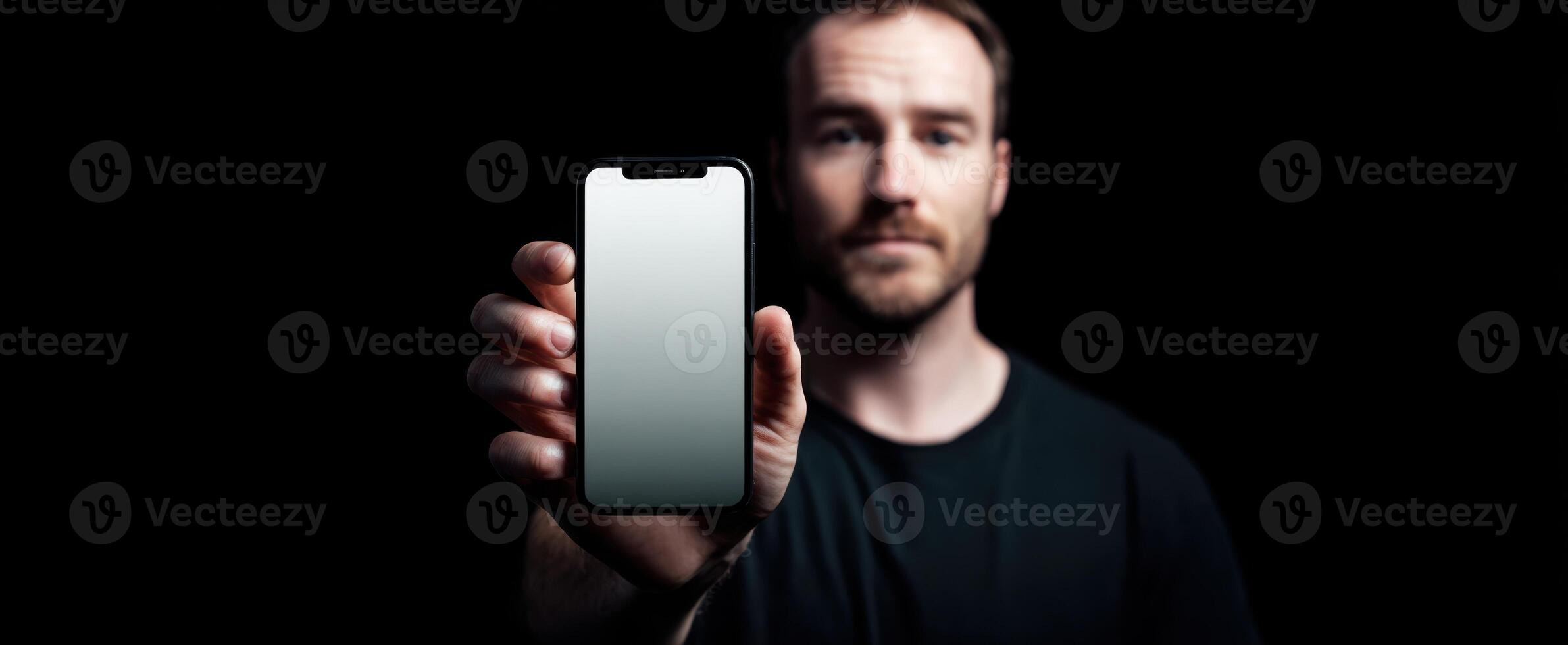 The modern man holding a smartphone in a dark and stylish setting. photo