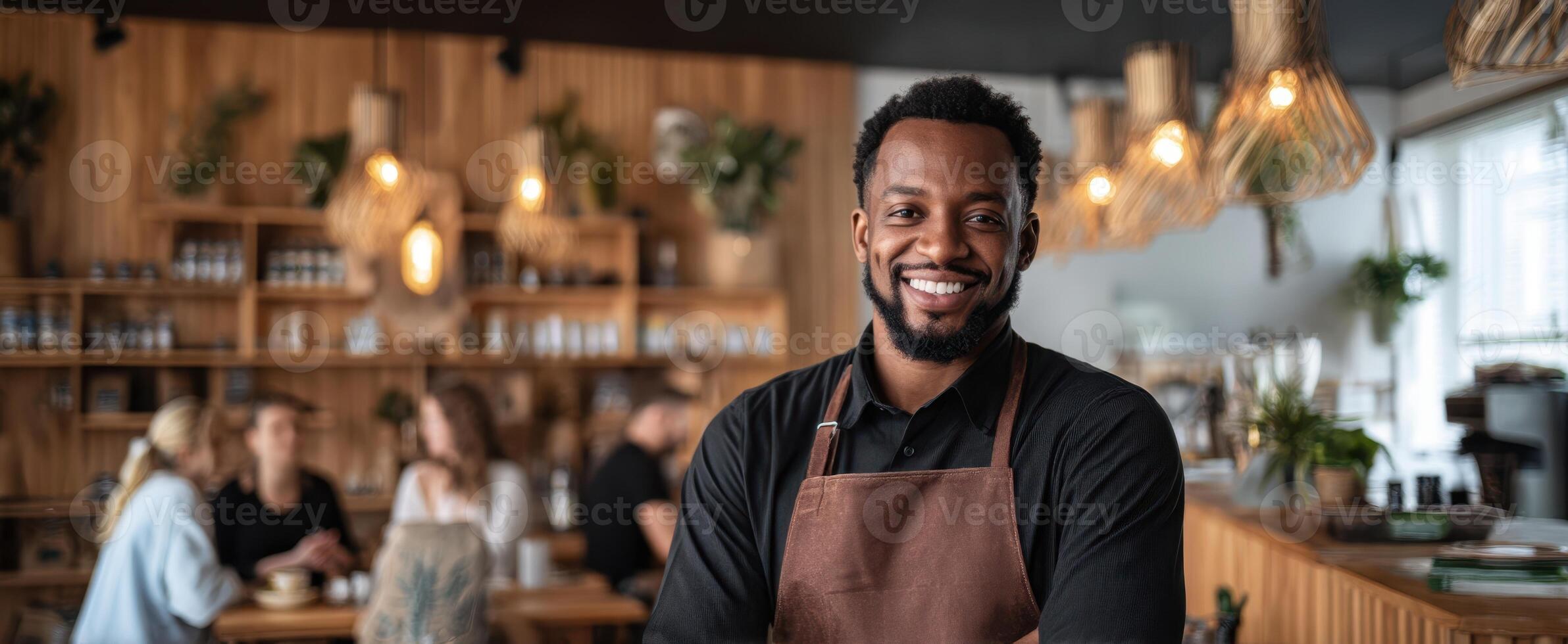 A smiling black man in an apron standing in front of a restaurant photo
